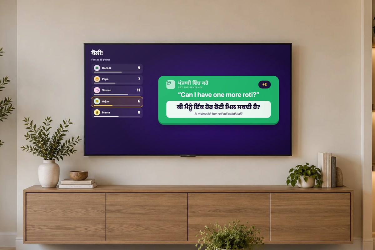 Boli on a living-room TV: the family scoreboard next to a Say the sentence card, Can I have one more roti?